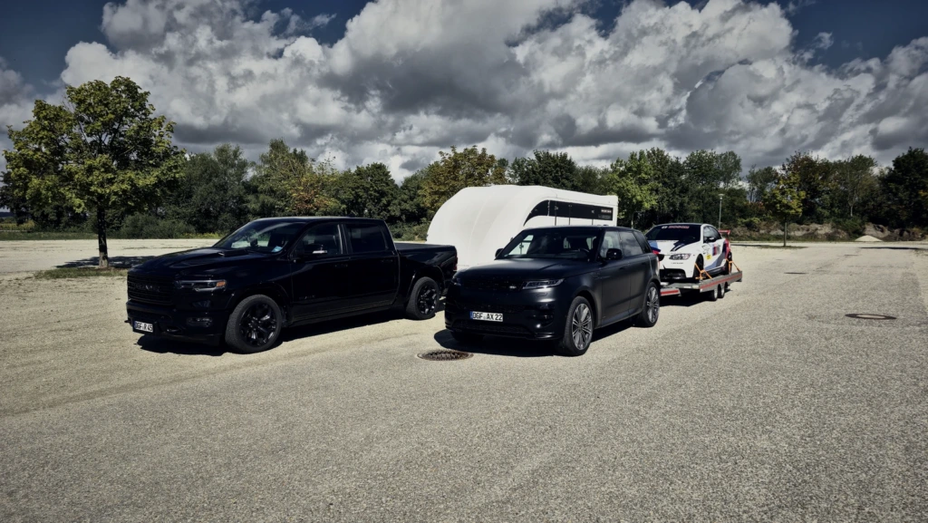 Beide Gespanne nebeneinander: der RAM 1500 mit dem geschlossenen Anhänger, der Range Rover mit der offenen Plattform.