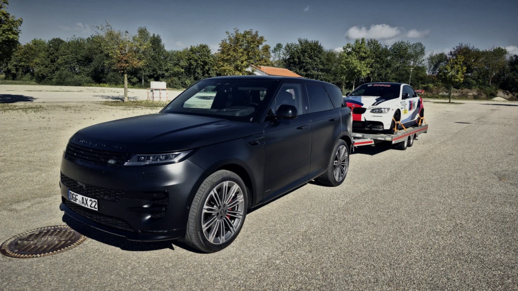 Der Range Rover mit beladener Plattform. Der BMW M3 (E93) steht verzurrt darauf.