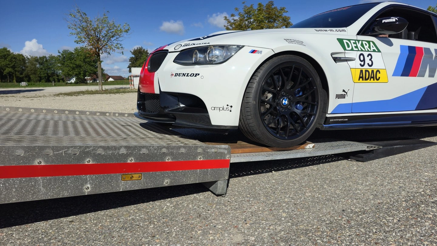 Front eines BMW M3 mit Rennbeklebung an der flachen Rampe der offenen Plattform