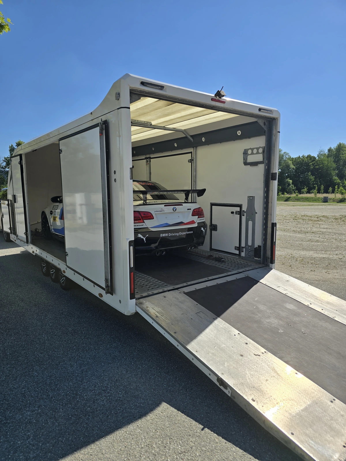BMW M3 von hinten im geschlossenen Anhänger, die Rampe ist abgesenkt