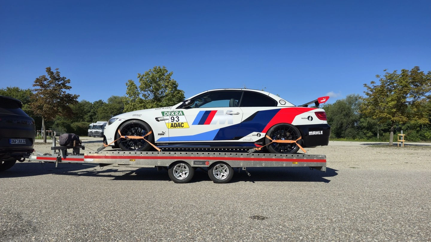 BMW M3 mit Heckflügel auf der offenen Plattform, mit vier Radgurten gesichert