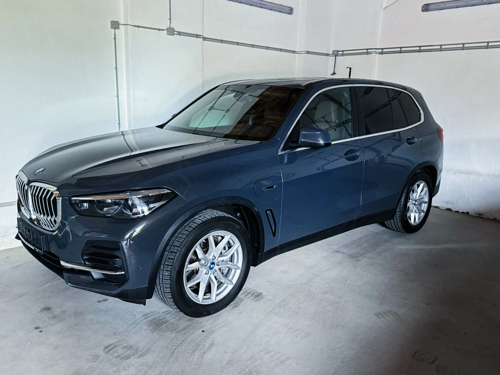Grauer BMW X5 in der Halle eines Autohauses vor der Abholung